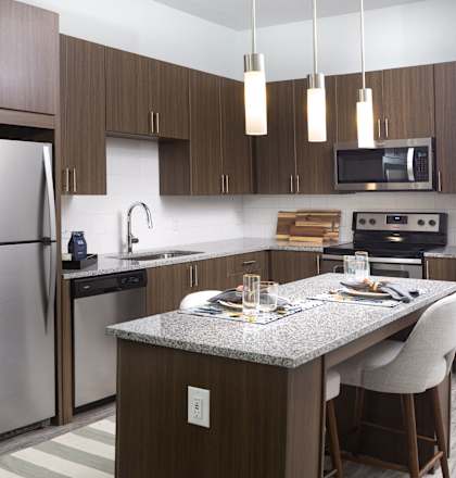 A modern kitchen with a stainless steel refrigerator and a granite countertop.