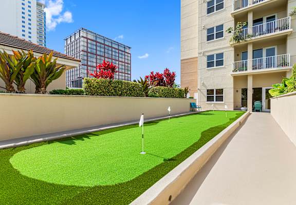 A miniature golf course is situated in the courtyard of a residential building.