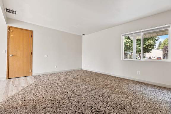 a bedroom with a large window and a wooden door