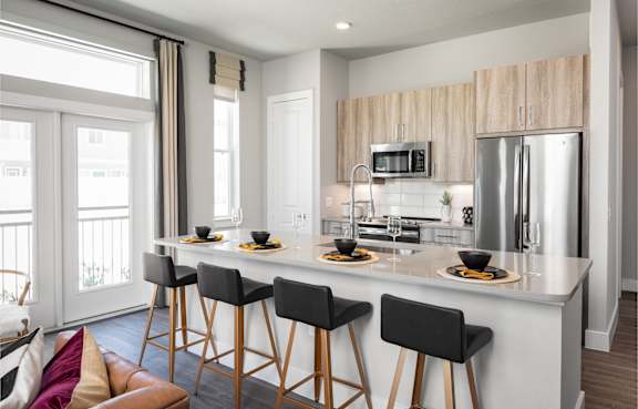 A modern kitchen with a bar area and a dining table.