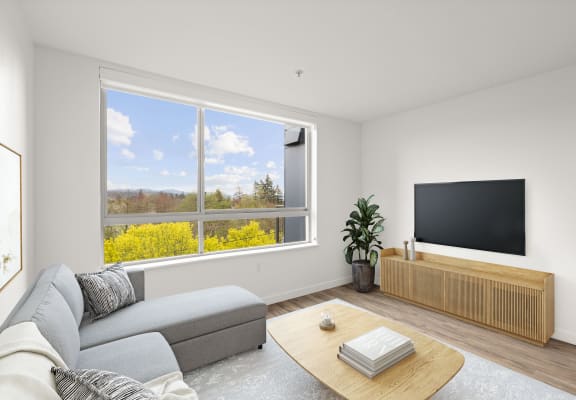 a living room with a large window with a view of a yellow rapeseed field