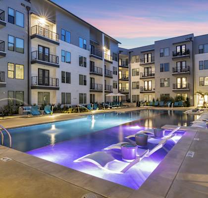 an apartment swimming pool with purple lights at night