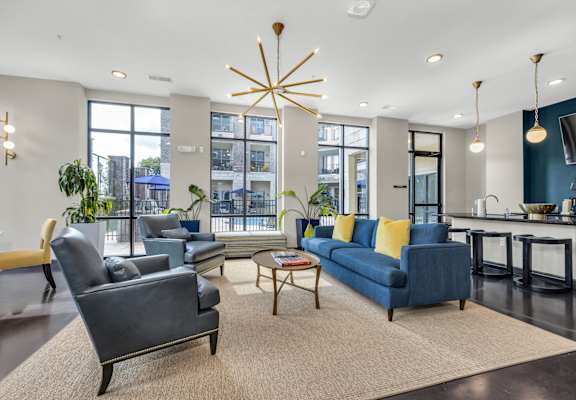 an open living room with couches and chairs and a kitchen with a large window at 17 Broad, Chattanooga, TN