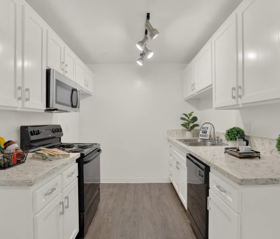 a kitchen with granite counter tops and white cabinets at Camino de Oro Apartments, Torrance, CA, 90505