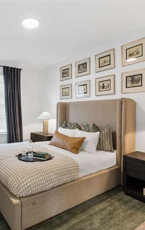 a bedroom with a large bed and a mirror at Nook Nine in Indianapolis, IN