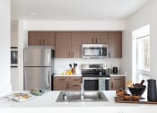 Thumbnail 2 of 4 - a kitchen with stainless steel appliances and wooden cabinets