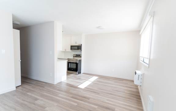 A kitchen with a microwave, oven, and a refrigerator.