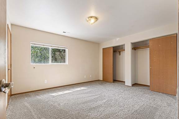 a bedroom with two doors and carpeted flooring