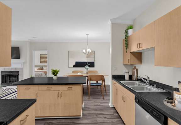 A kitchen with black countertops and wooden cabinets.