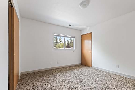 a bedroom with white walls and carpet
