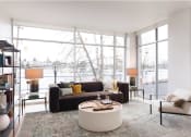 Thumbnail 1 of 4 - a living room with a brown couch and a white coffee table