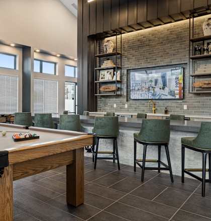 Luxury clubhouse at Nook Nine with a billiards table, bar seating, and modern decor.