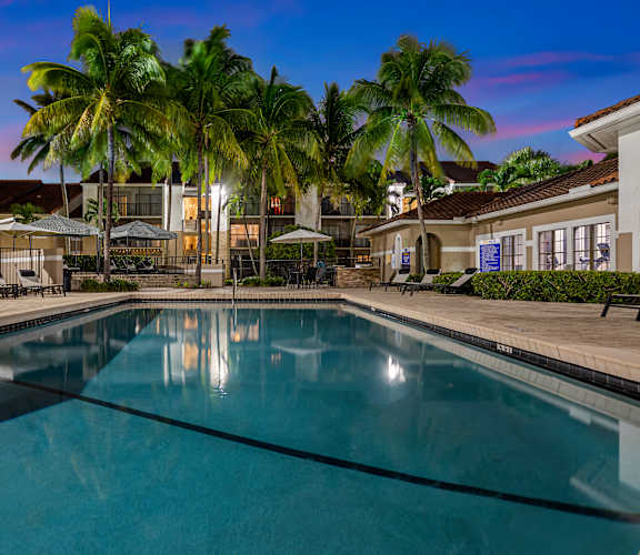 a large swimming pool with palm trees in the background