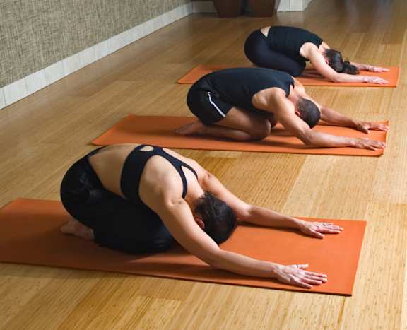 Three people doing yoga on orange mats in a row at Ironwood Apartments, Coeur d'Alene, Idaho
