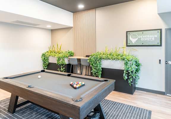 A pool table with a green cloth and balls in the middle of it.