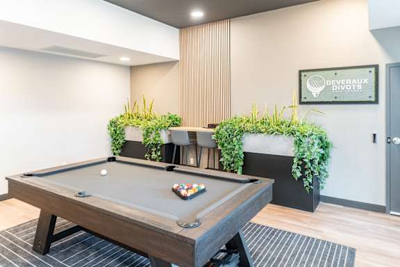 A pool table with a green cloth and balls in the middle of it.
