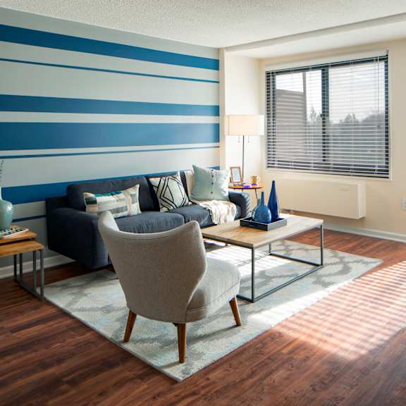 A living room with a blue and white striped wall.