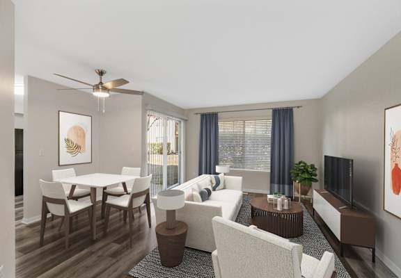A living room with a white couch, a wooden dining table, and a ceiling fan.
