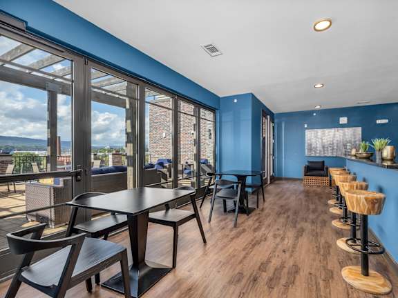 a dining area with tables and chairs and large windows