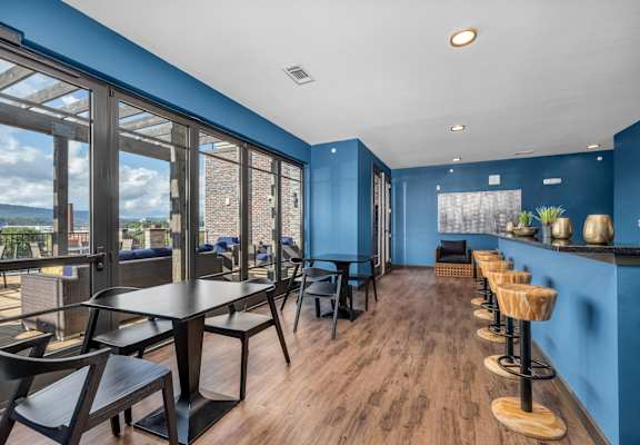 a dining area with tables and chairs and large windows at 17 Broad, Chattanooga, 37408