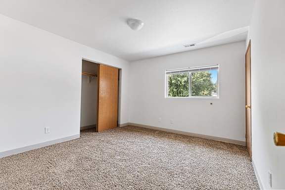 a bedroom with white walls and carpet