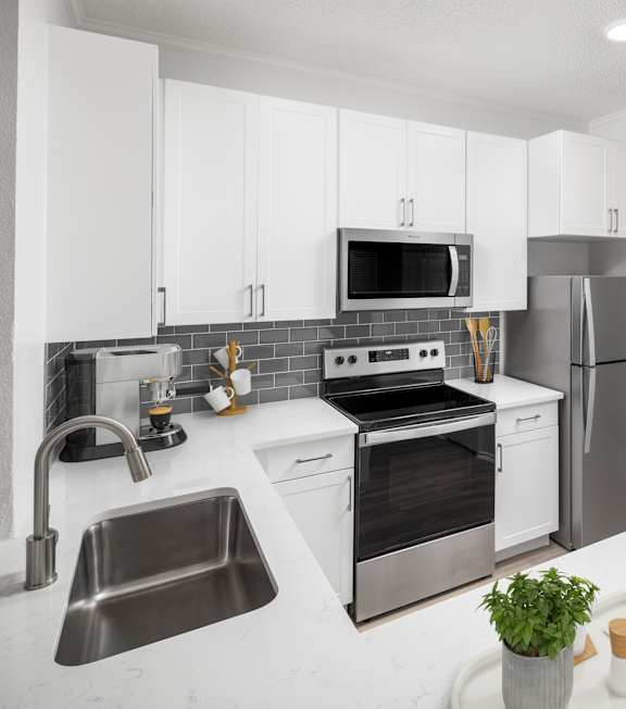 A modern kitchen with stainless steel appliances and white cabinetry.