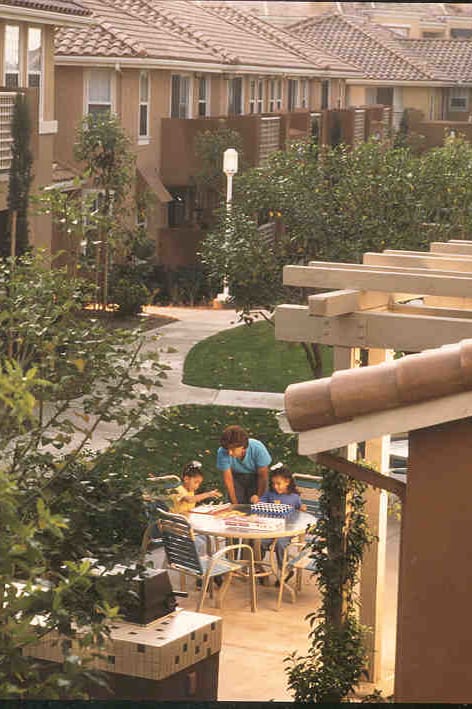 the courtyard between the two buildings is filled with benches and plants