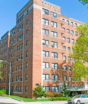 a tall brick building with a car parked in front of it