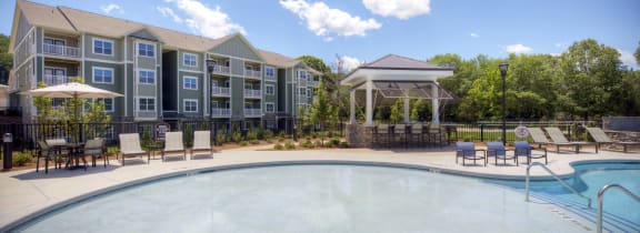 an outdoor pool with an apartment building in the background