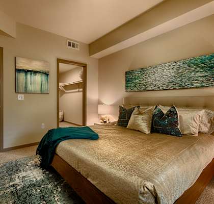 a master bedroom with a large bed and a walk in closet