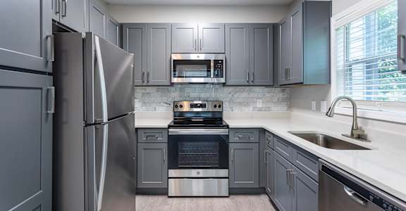 A modern kitchen with a stainless steel refrigerator and oven.