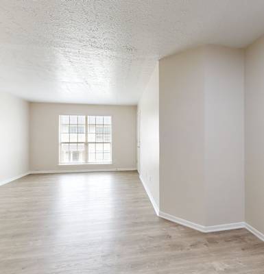 an empty living room with white walls and a window