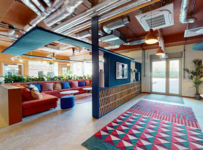 a room with couches and chairs and a rug in the middle of the room