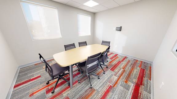 A conference room with a table and chairs.