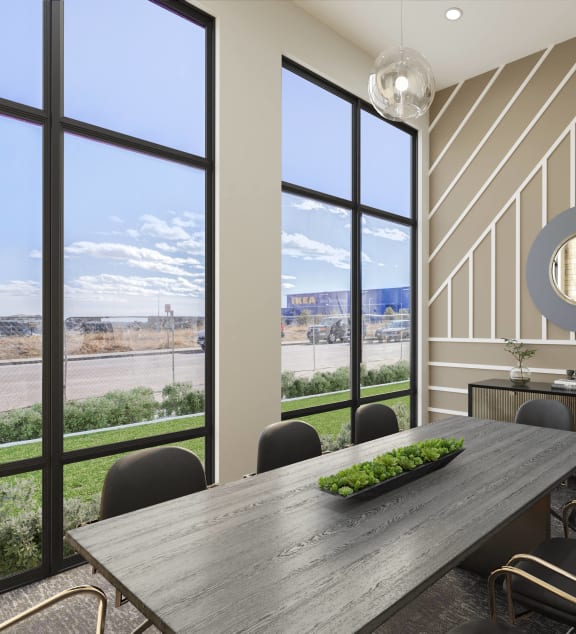 a dining room with a table and chairs and large windows