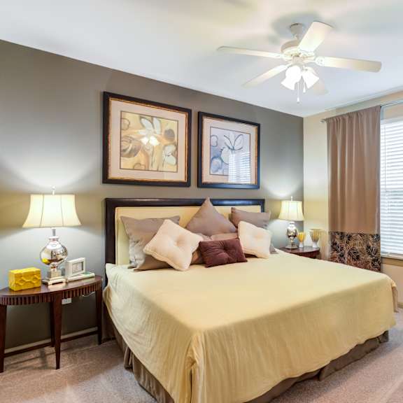 A bedroom with a large bed and a ceiling fan.