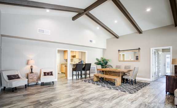A spacious living room with a wooden floor and a high ceiling.