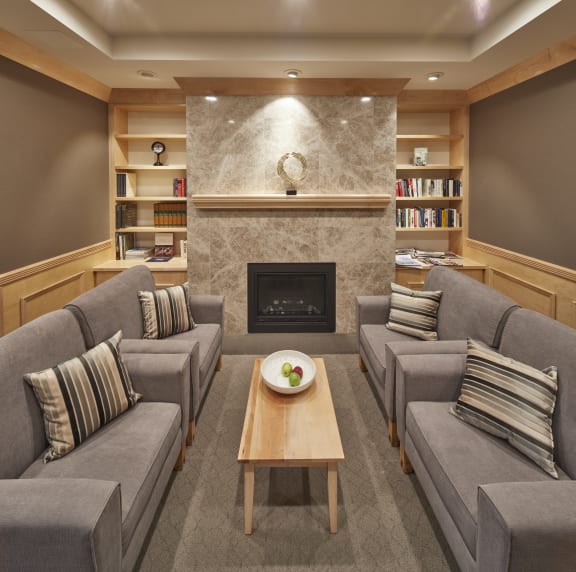 A living room filled with couches, tables, and a fireplace