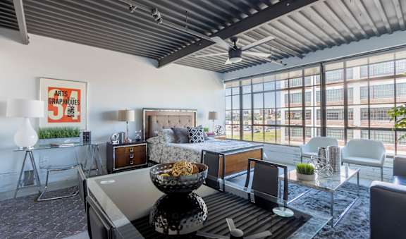A modern living room with a glass table and a bowl of popcorn on it.