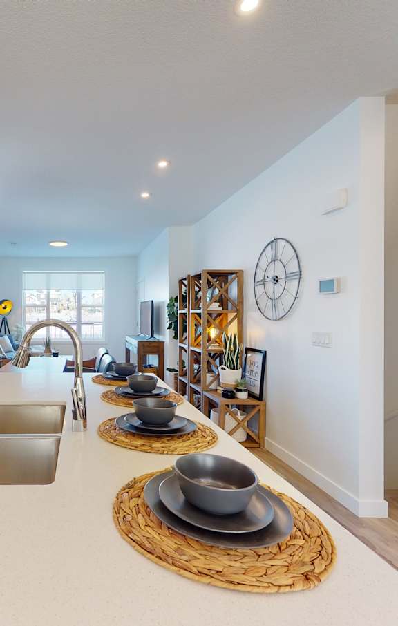 A living room with a long wooden table and chairs.