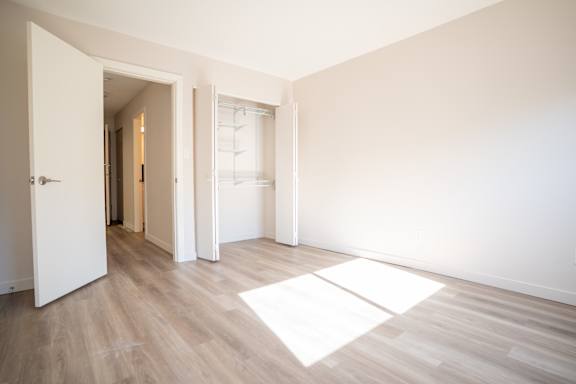 A room with a white door and a white mat on the floor.