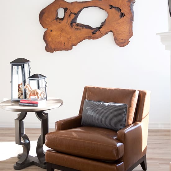 a living room with a brown leather chair and a skull on the wall