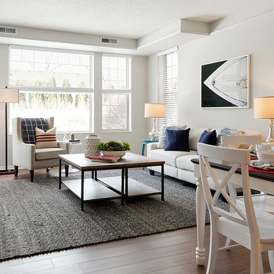 a living room with a table and chairs and a couch in front of a window