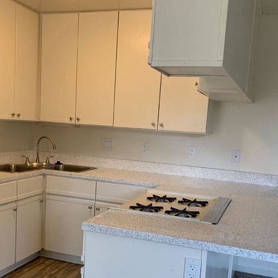 a kitchen with white cabinets and a stove and a sink