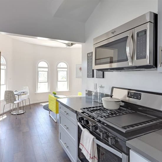 a kitchen with a stove top oven next to a microwave