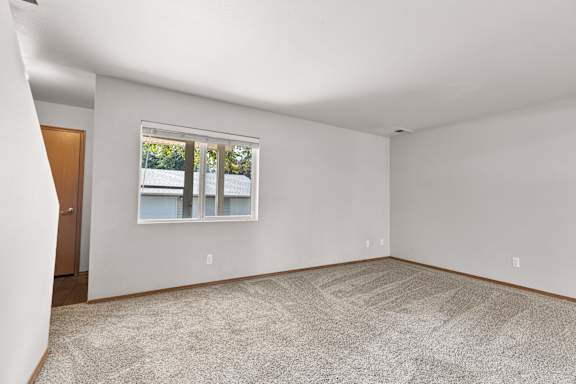 a bedroom with gray walls and a large window