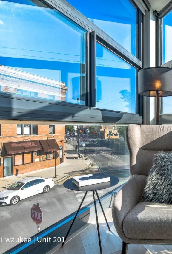 a living room with a chair and a window overlooking a street