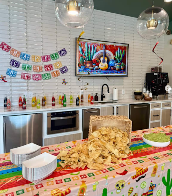 A Mexican themed party with a table full of chips and guacamole.