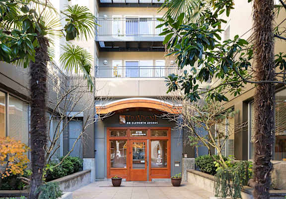 The entrance to a building with a brown door and a sign above it.