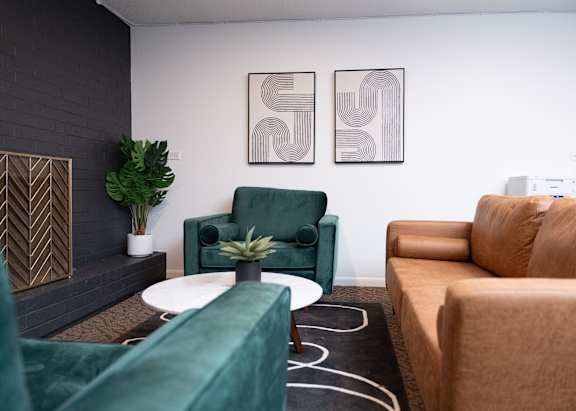 A living room with a green chair and a brown couch.
